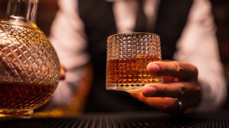Hand holding a glass of scotch