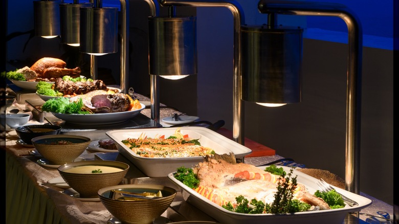 Buffet-style trays of food under warming lamps