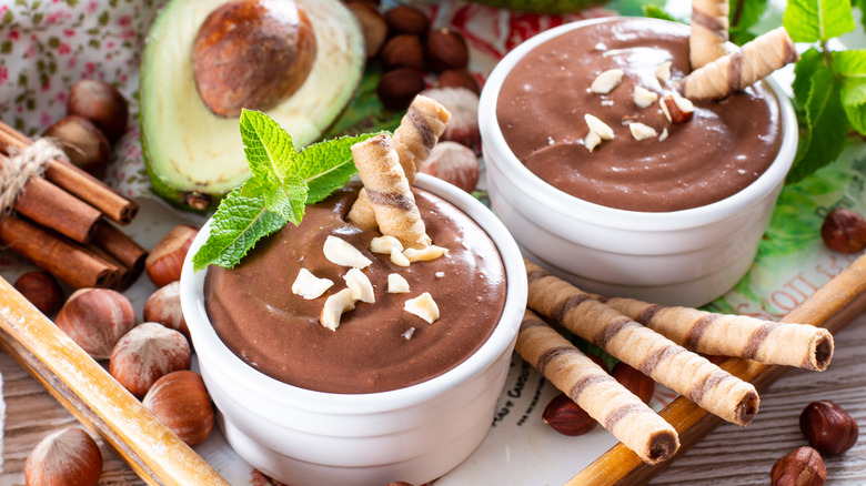 Chocolate avocado mousse with avocado behind it