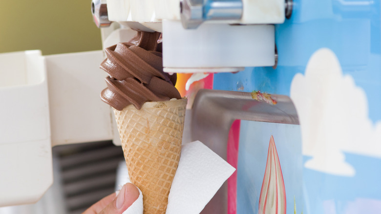 A man filling a sugar cone with frozen custard