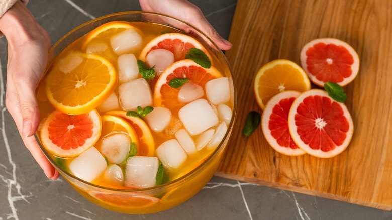 Holding a large bowl of punch