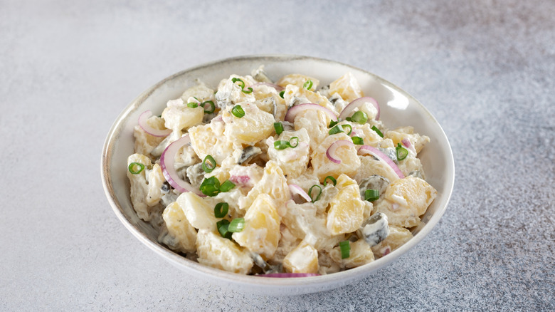 White bowl full of creamy potato salad