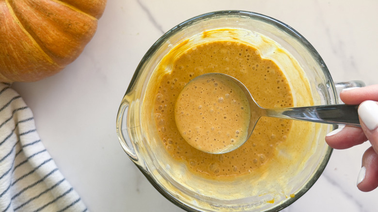 hand holding ladle of pumpkin mixture