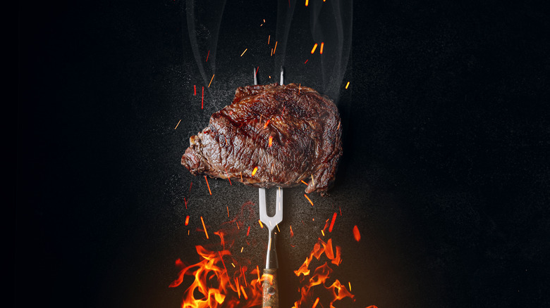 grilled steak over flames