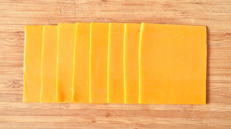 Thick layered slices of American cheese on a wood surface