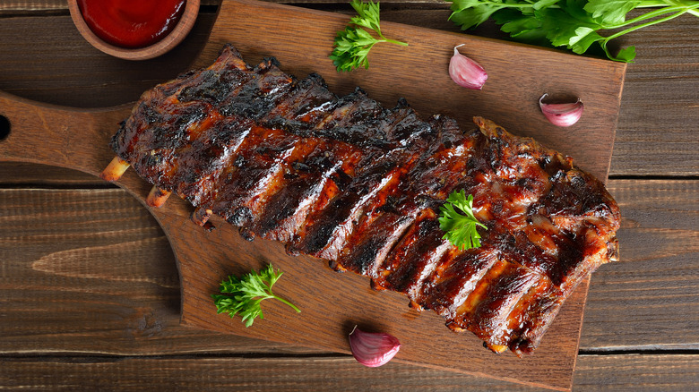 A rack of pork ribs on a cutting board is photographed from above