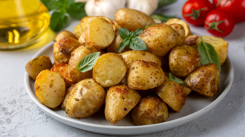 Roasted potatoes topped with fresh herbs on a white plate