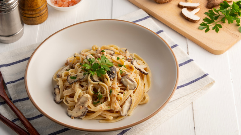 a bowl of creamy mushroom pasta topped with fresh parsley