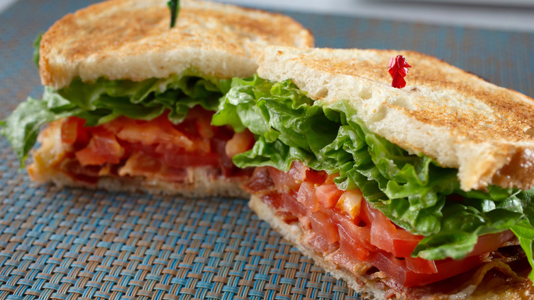 BLT sandwich cut in half with a toothpick in each half.