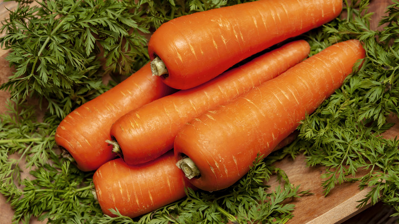 orange carrots on a wooden cutting board