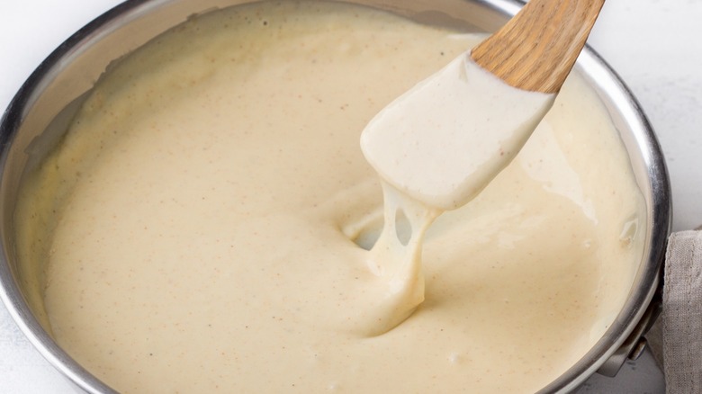 a bowl of cheese sauce on table