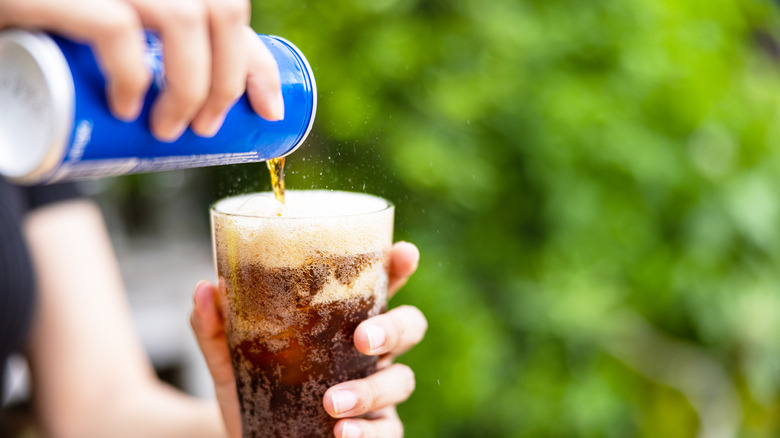 Pouring soda from can into glass