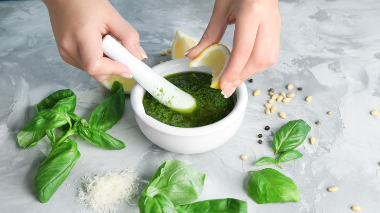 Wanita menambahkan jus lemon ke pesto