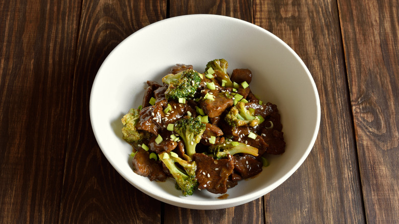 Beef with broccoli in a bowl on a wooden surface