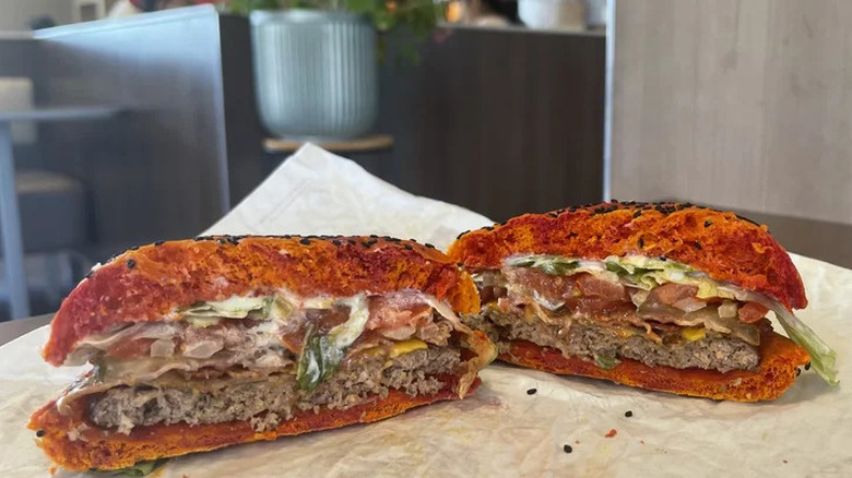 Holding a wrapped Whopper Jr from Burger King