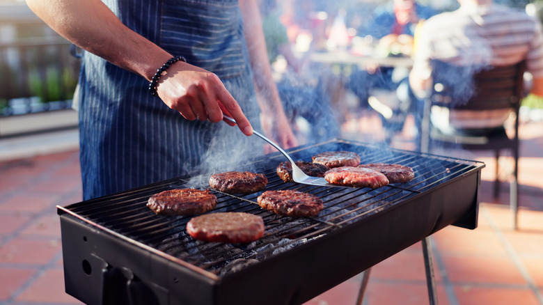 Person cooking burger patties