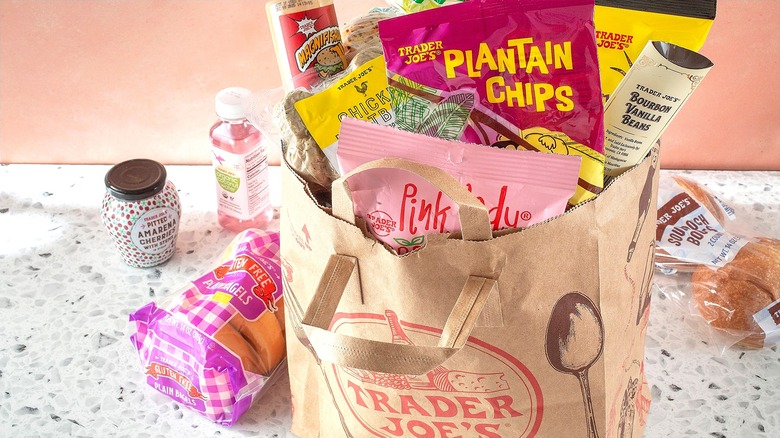 Bag of Trader Joe's private label products against a light pink background.