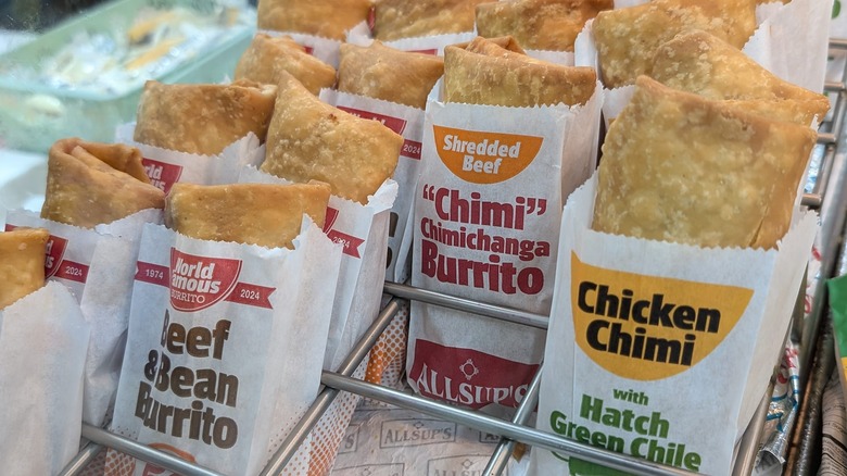 Multiple rows of Allsup's fried burritos in a metal rack