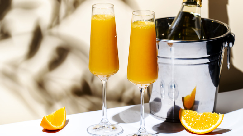 Mimosas next to a bucket of champagne