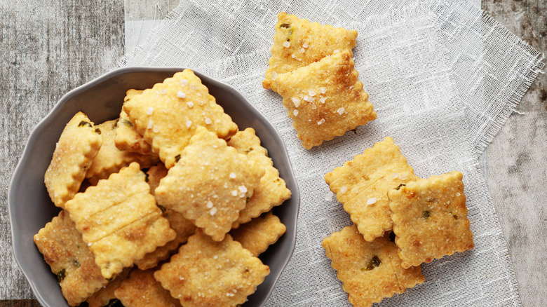 Crackers in a bowl and spread out beside the bowl