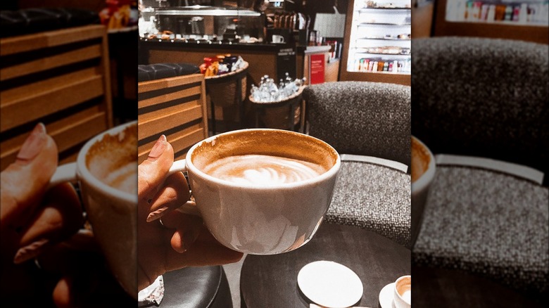 Person holding cup of coffee