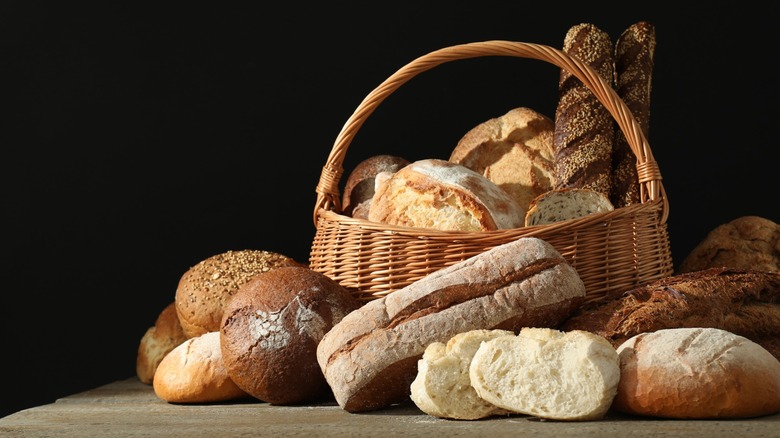 Different kinds of bread in and around a basket