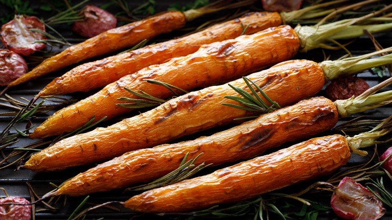 An illustrative image showing several grilled carrots with herbs.