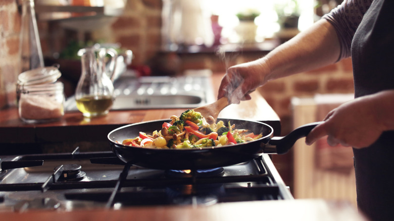 Woman stir-frying vegetables