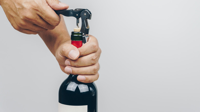Opening wine bottle with corkscrew