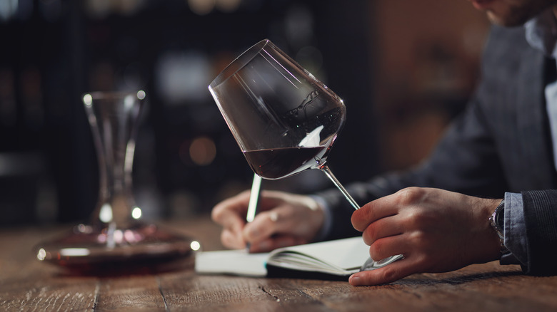 Holding glass of red wine
