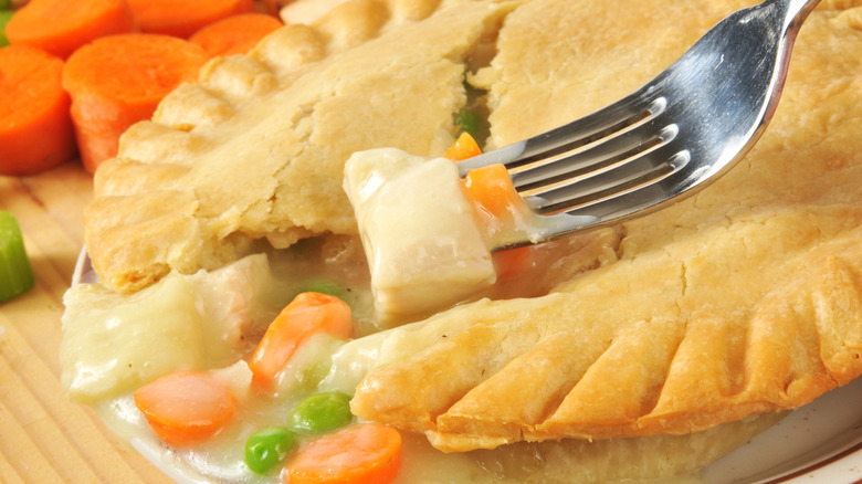 Close up of a chicken pot pie with chicken on a fork