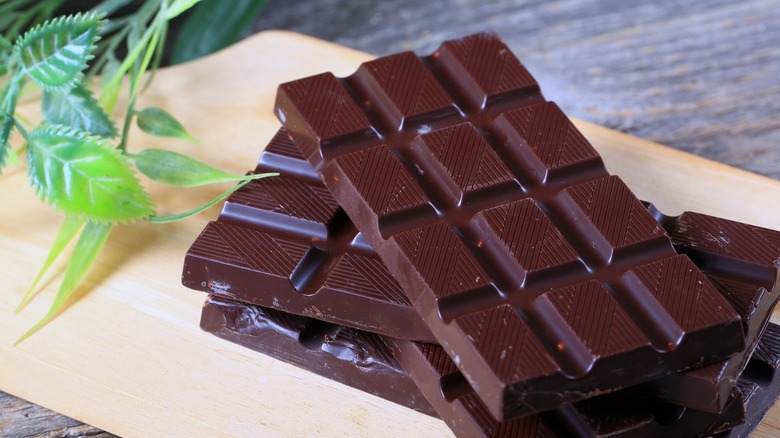 Unwrapped bars of dark chocolate on table