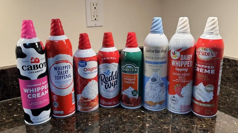 Several canned whipped cream varieties in a row.
