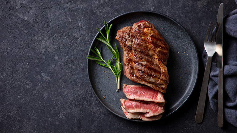 Cooked steak on black plate