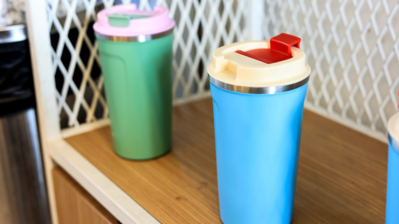 Two colorful tumblers on a shelf