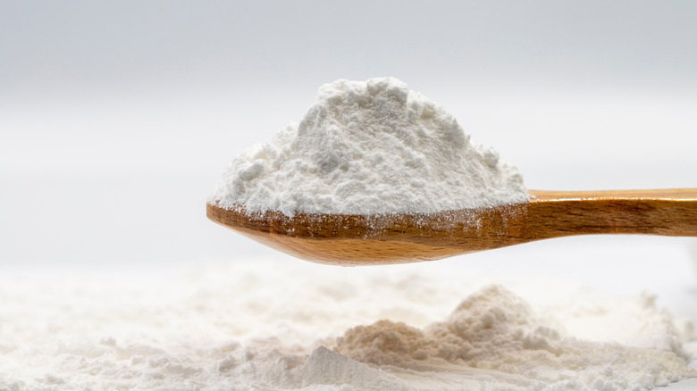 A heap of powdered sugar on a wooden spoon