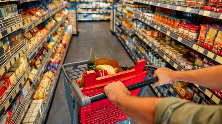 a man pushing a cart full of groceries in a supermarket