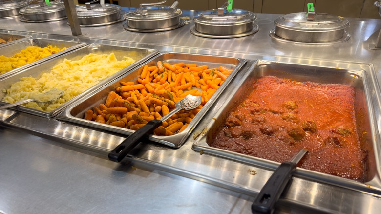fried zucchini, mashed potatoes, and meatballs in serving trays at Whole Foods' hot food bar