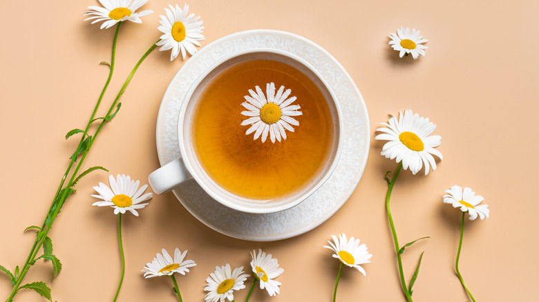 A chamomile tea cup on a beige background.