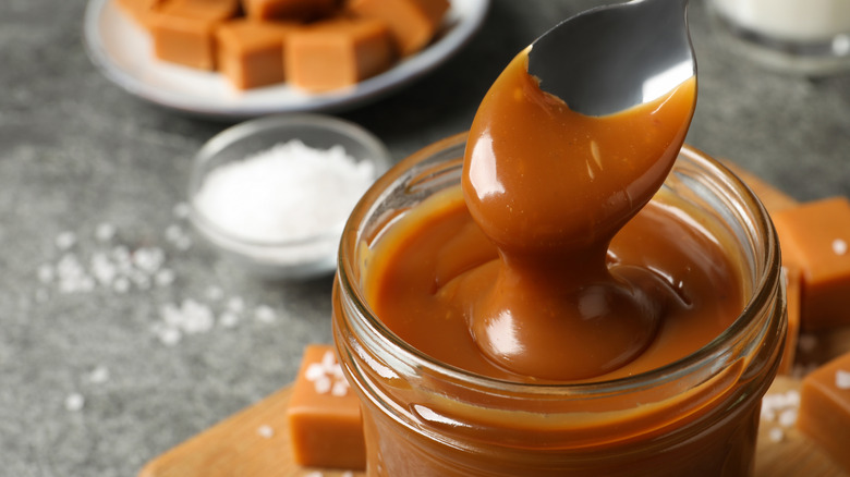 Spoon dipping into salted caramel sauce