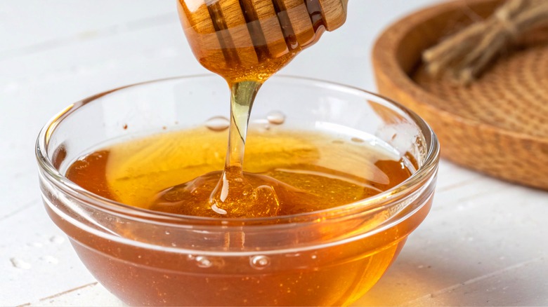 Honey dipper taking honey from a bowl