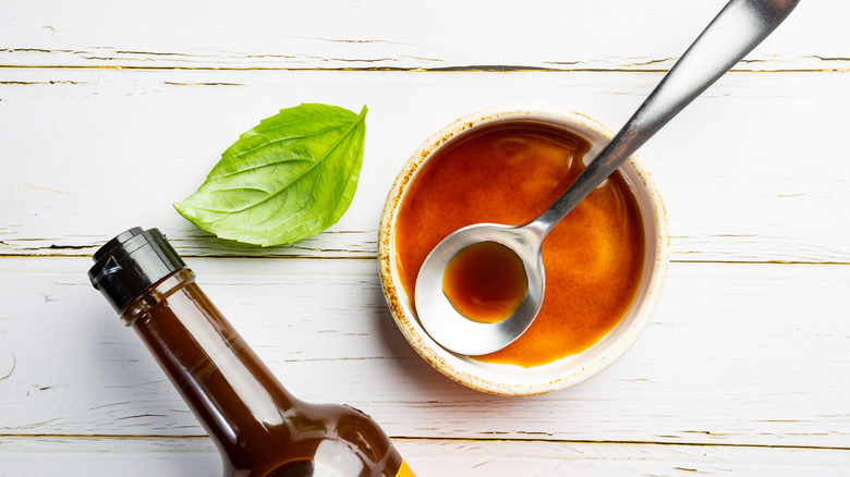 Worcestershire sauce in ceramic bowl with metal spoon