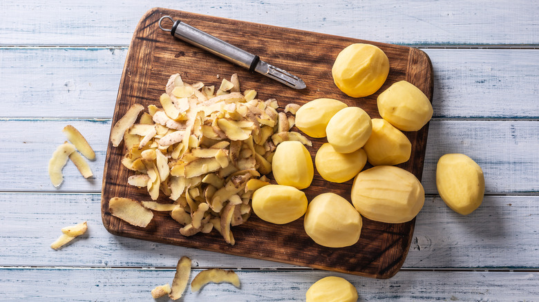 Peeled potatoes with their skin on the side
