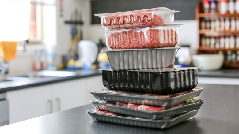 Different packaged meat stacked on a kitchen counter