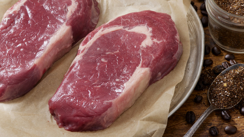 A juicy raw steak on a parchment paper