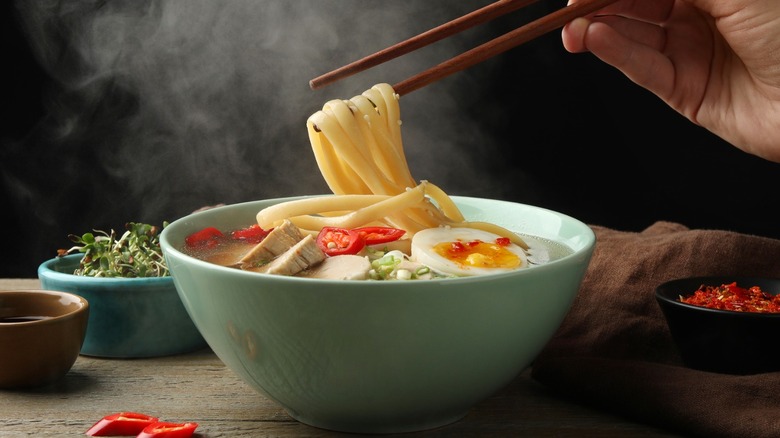 Steaming bowl of spicy noodle soup