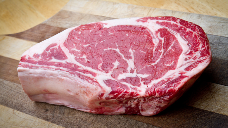Ribeye steak on wooden cutting board