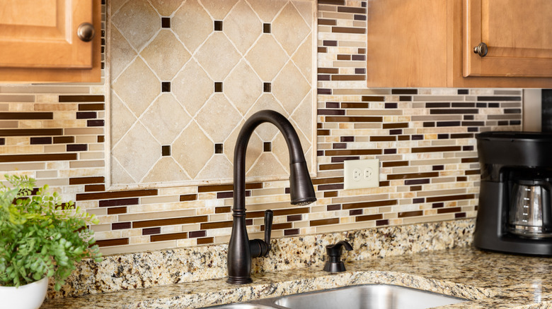 kitchen sink detail with taupe and beige mosaic tile backsplash