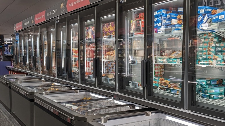 Two Aldi employees restocking the frozen section in store.