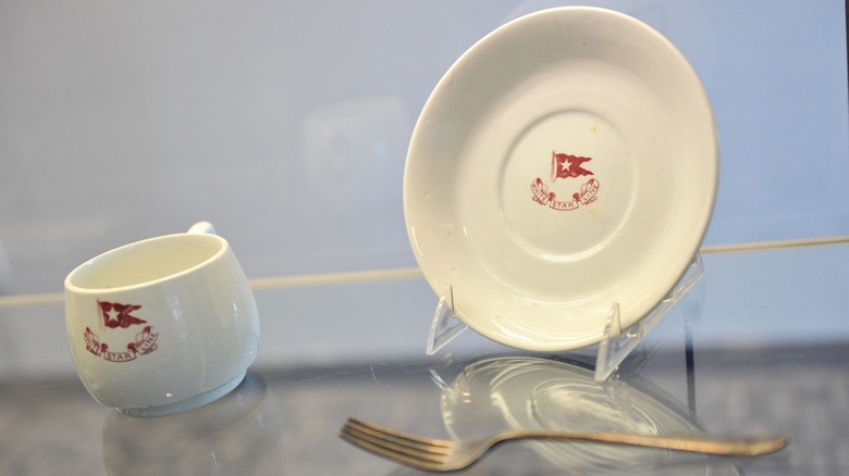 A White Star Line cup, saucer, and fork recovered from the Titanic on display at the Titanic museum.